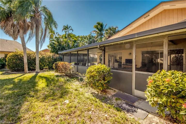 View of green lawn featuring a sunroom