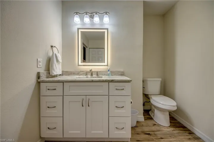 Bathroom featuring vanity, light wood finished floors, and a textured wall
