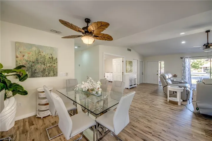 Dining area featuring a ceiling fan, lofted ceiling, light wood finished floors, and recessed lighting