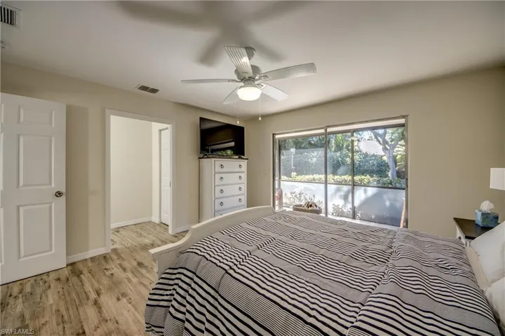 Bedroom with light wood-style flooring, access to outside, and ceiling fan