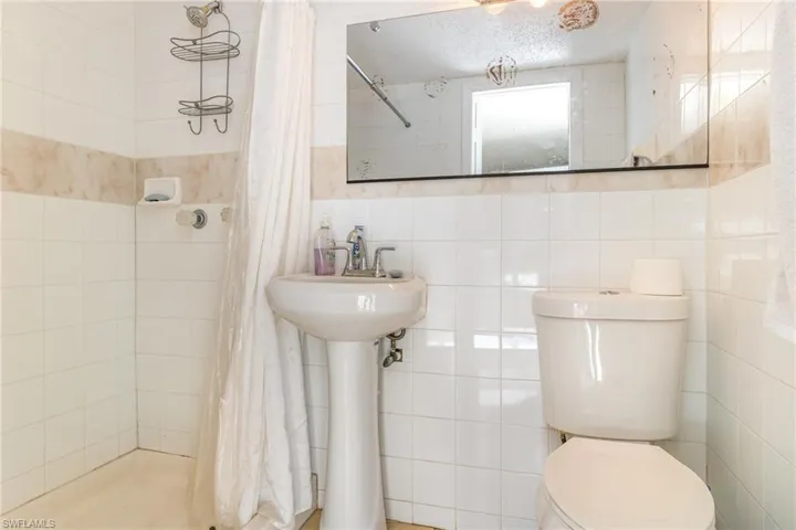 Full bathroom with tile walls and a stall shower