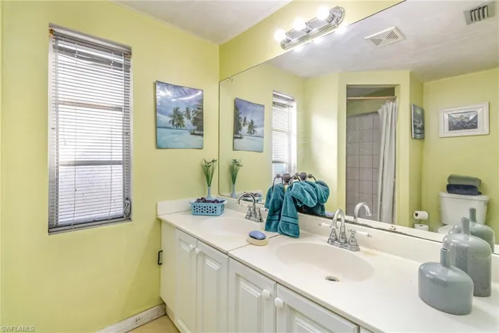 Bathroom featuring double vanity and a shower with shower curtain