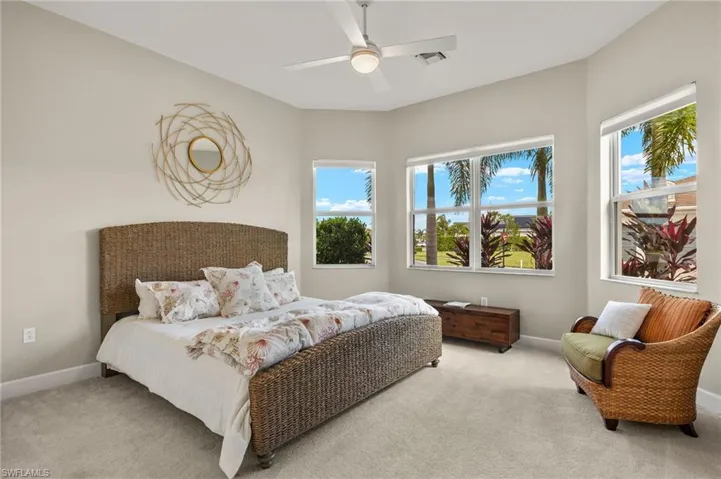 Carpeted bedroom 2 featuring multiple windows and ceiling fan