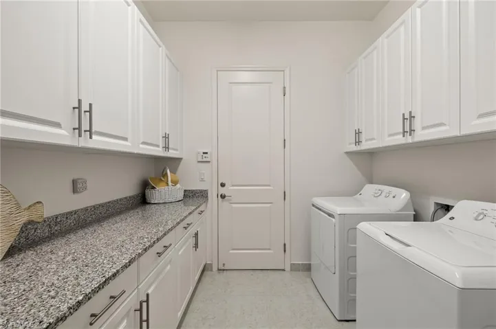 Laundry room with cabinets and washer and clothes dryer
