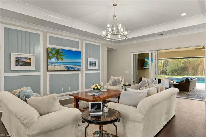 Living room featuring ornamental molding, a notable chandelier, and dark hardwood / wood-style floors