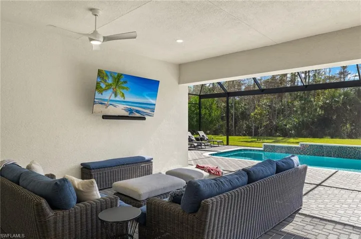 View of patio with glass enclosure and ceiling fan