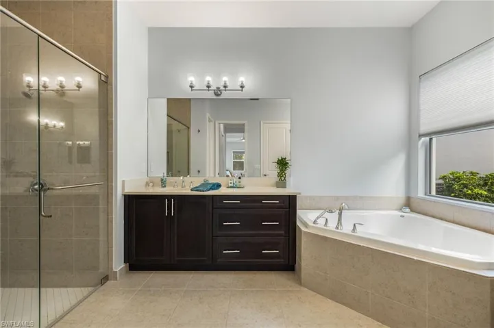 Bathroom featuring vanity, plus walk in shower, and tile patterned flooring