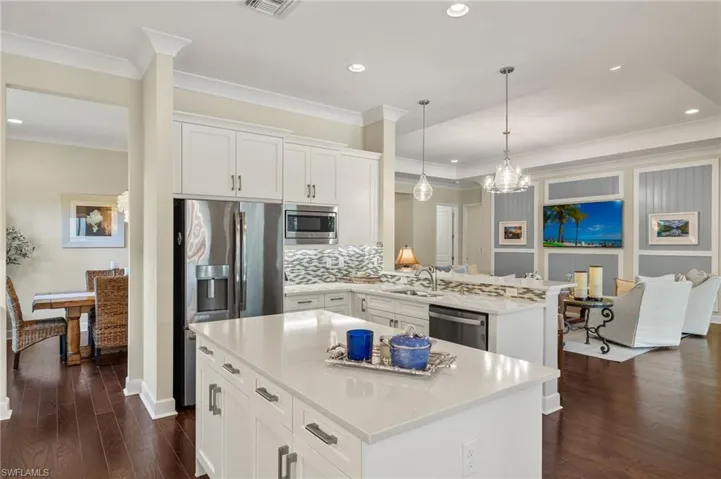Kitchen featuring stainless steel appliances, dark hardwood / wood-style flooring, white cabinetry, and a kitchen island
