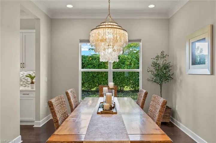 Dining room with a notable chandelier, dark hardwood / wood-style floors, and crown molding