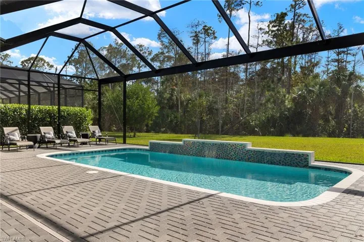 View of swimming pool featuring a lanai, a patio, and a yard
