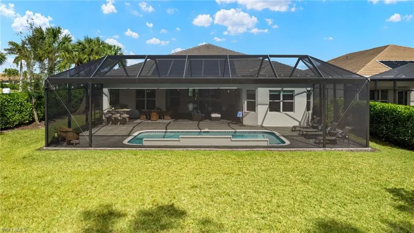 Back of house featuring glass enclosure, a yard, and a patio area