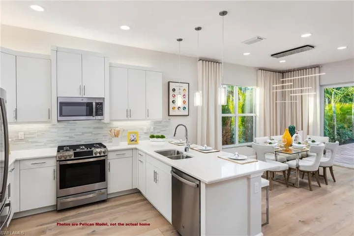 Kitchen featuring sink, tasteful backsplash, stainless steel appliances, and light hardwood / wood-style floors