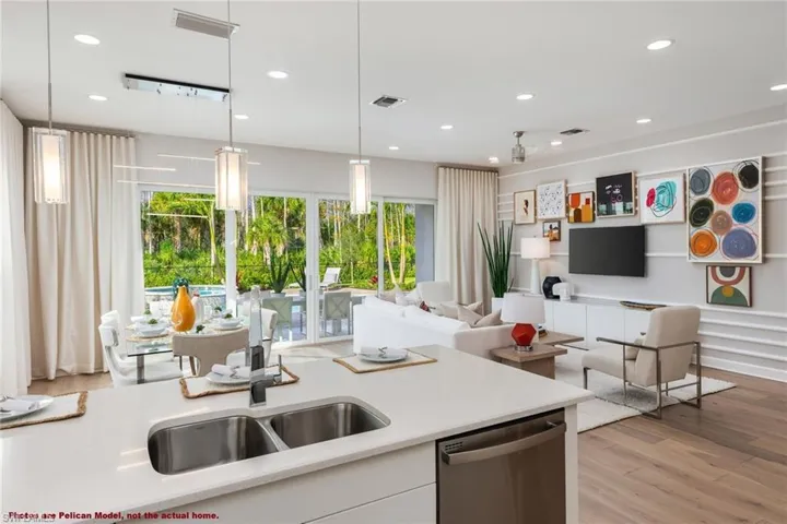Kitchen featuring dishwasher, light hardwood / wood-style floors, decorative light fixtures, and a wealth of natural light