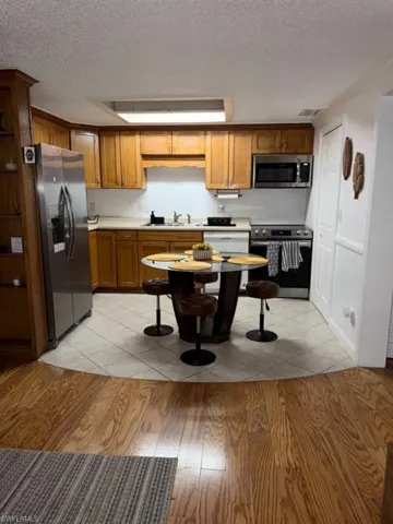 Kitchen featuring wood cabinetry, stainless steel appliances, and a tile floor
