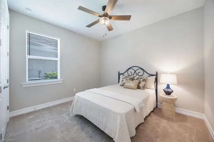 Carpeted bedroom featuring baseboards and ceiling fan