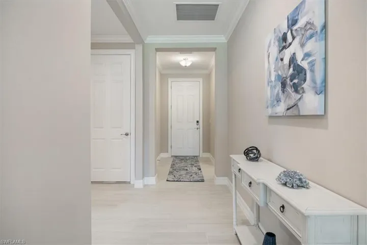 Hallway featuring crown molding and baseboards