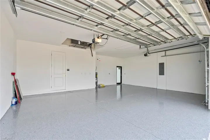 Garage with electric panel and a garage door opener