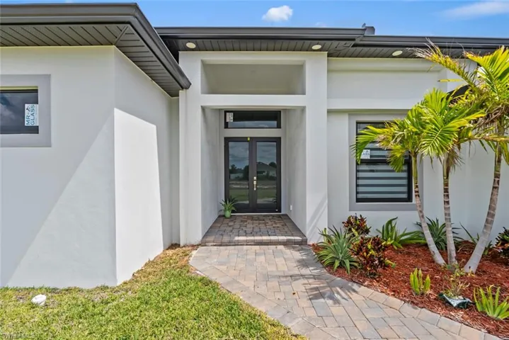 View of exterior entry with stucco siding and french doors