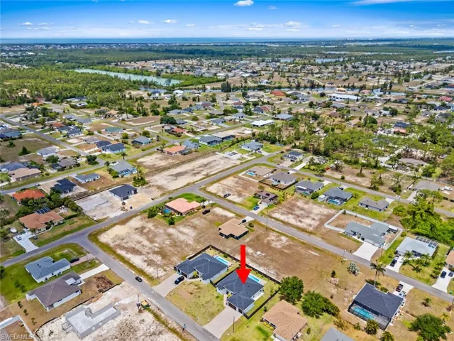 Aerial perspective of suburban area featuring a nearby body of water