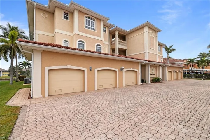 View of front of house with central AC unit, a balcony, and a garage