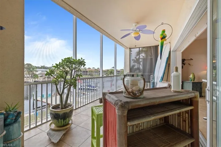 Sunroom featuring a water view and ceiling fan