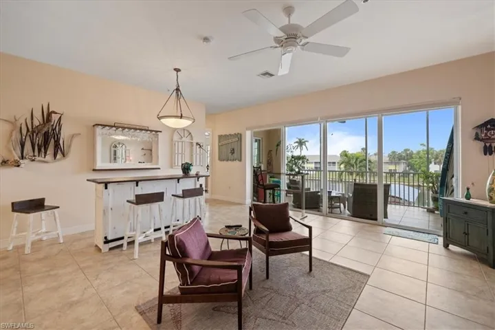Living area featuring ceiling fan and light tile patterned floors