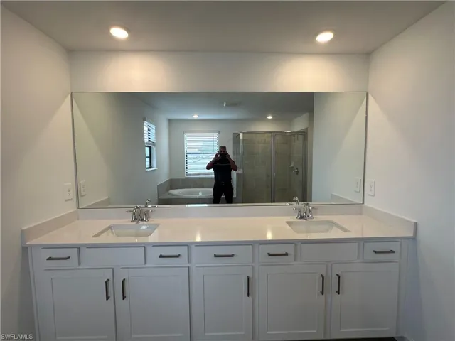 Bathroom featuring double vanity and plus walk in shower