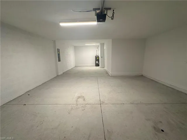 Garage featuring a garage door opener and water heater