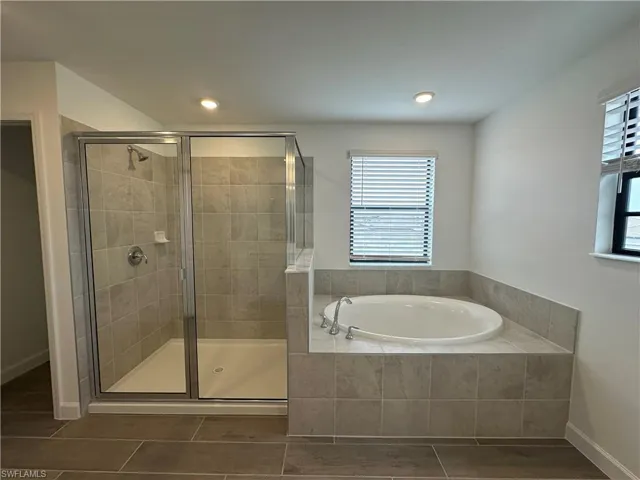 Bathroom featuring plus walk in shower and tile patterned floors