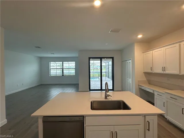 Kitchen with dishwashing machine, a kitchen island with sink, sink, and stainless steel dishwasher