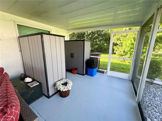 View of extended screened lanai new in 2023 with storage sheds.