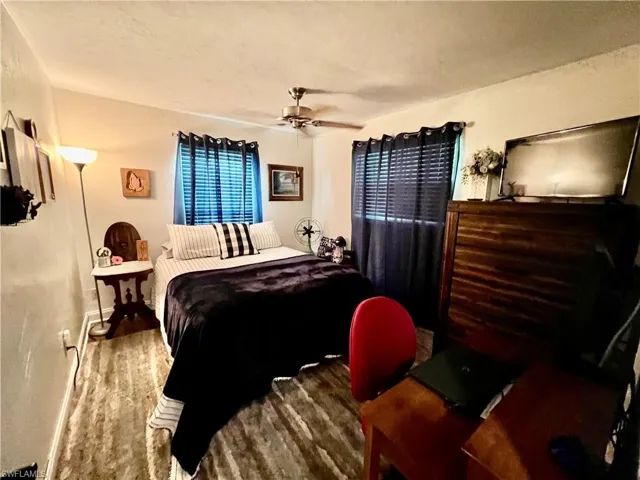 Bedroom featuring ceiling fan and luxury vinyl wood like floors.