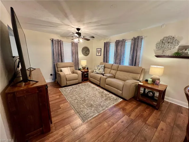 Living room featuring ceiling fan and luxury vinyl plank flooring.