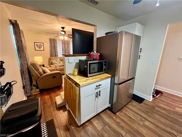 Kitchen with appliances with stainless steel finishes, luxury vinyl plank flooring, ceiling fan, and white cabinets