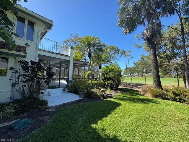 View of yard with a balcony and a sunroom
