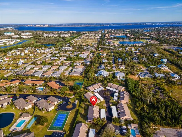 Aerial view of property and surrounding area with nearby suburban area and a large body of water