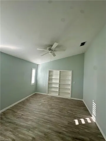 master bedroom with dark wood-style flooring, a new ceiling fan, and lofted ceiling