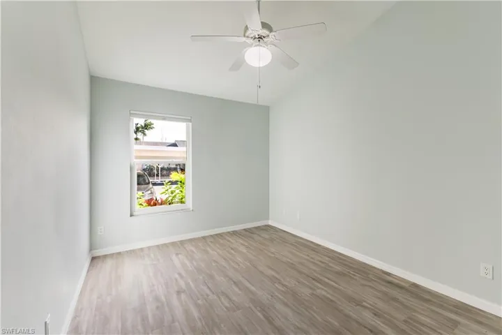 2nd bedroom featuring wood finished floors, a ceiling fan, and lofted ceiling