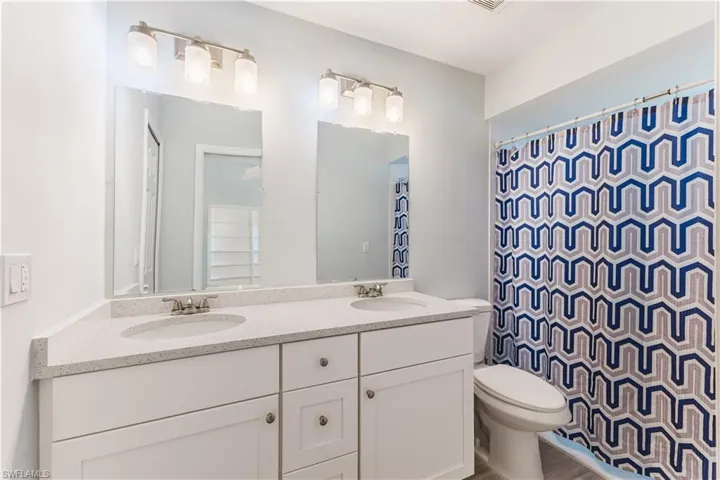Master Bathroom featuring double vanity and curtained shower