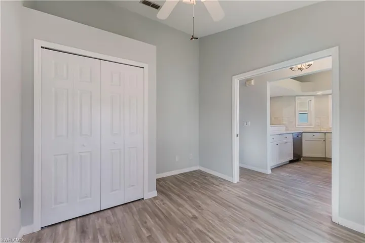 3rd bedroom with light wood-style floors, a closet, ceiling fan, and a chandelier