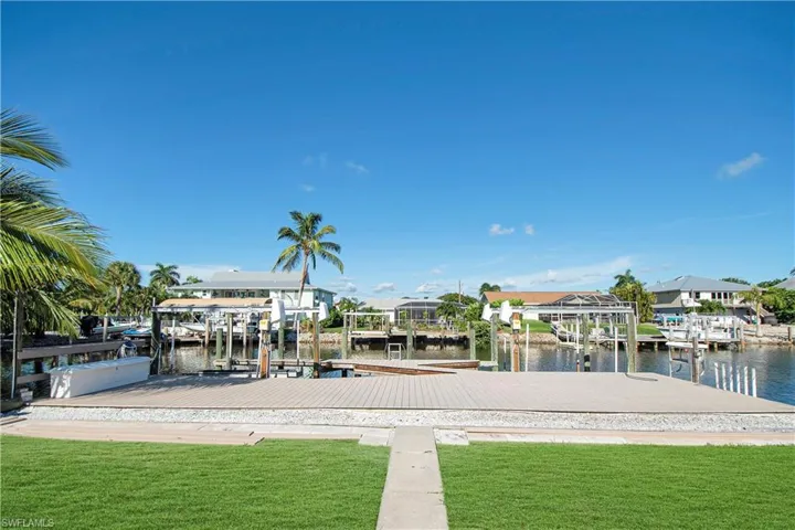 View of dock with a water view and a yard