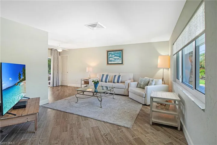Living room with ceiling fan and wood-type tile flooring