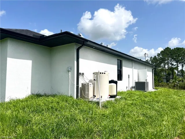 Rear view of house featuring stucco siding and central air condition unit