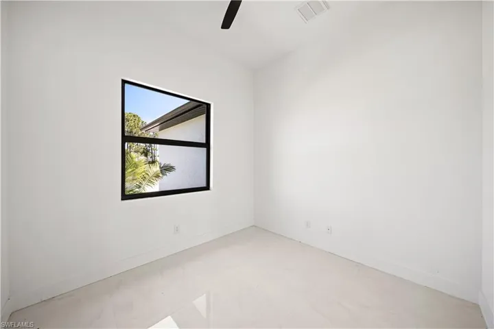 Unfurnished room with ceiling fan, baseboards, and light marble finish flooring