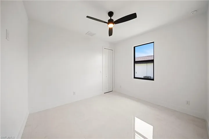 Spare room featuring ceiling fan and baseboards