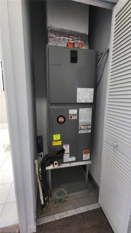 Utility closet housing a vertical air handler unit with visible ductwork