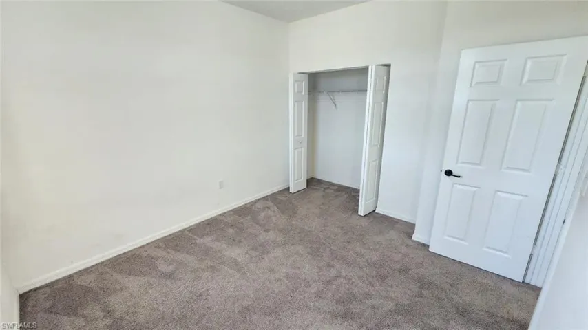 Neutral-toned carpeting paired with white walls, baseboards, and trim