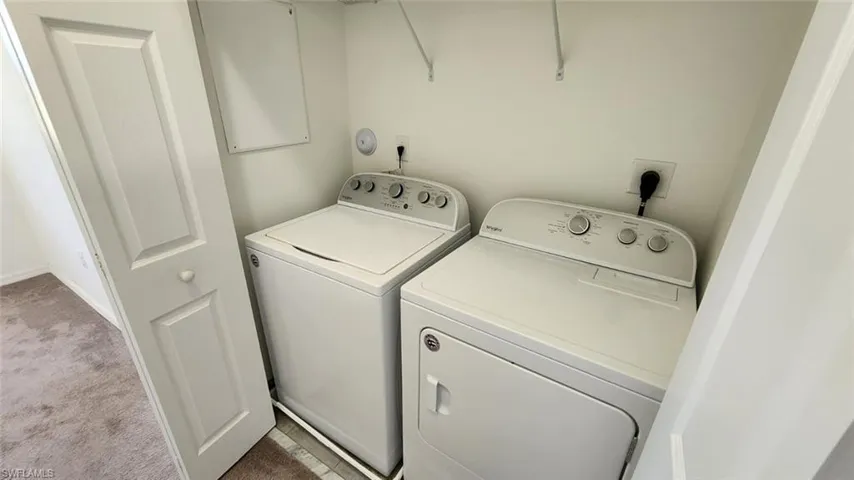 Dedicated laundry area featuring a white top-load washing machine and front-load dryer
