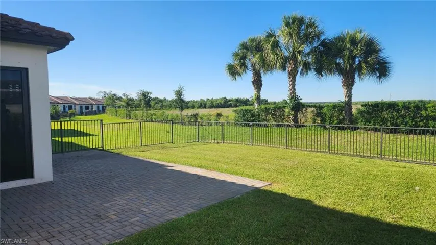 Expansive backyard featuring a paver patio and green lawn