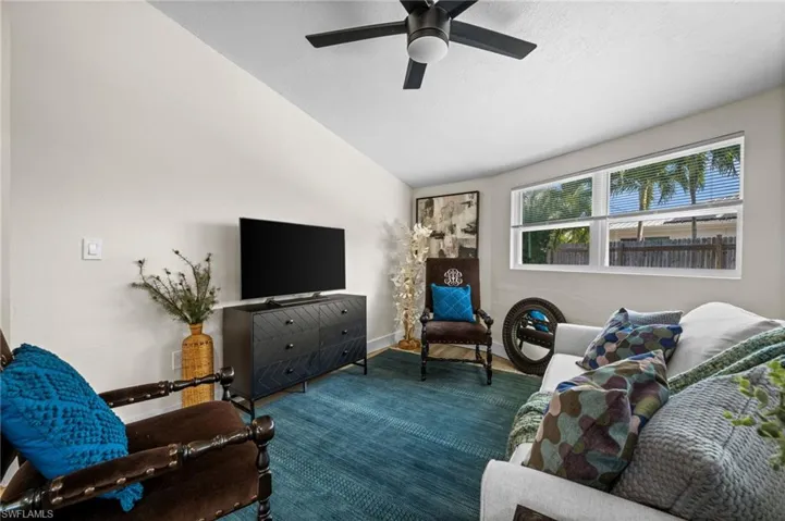 Living area featuring vaulted ceiling and a ceiling fan